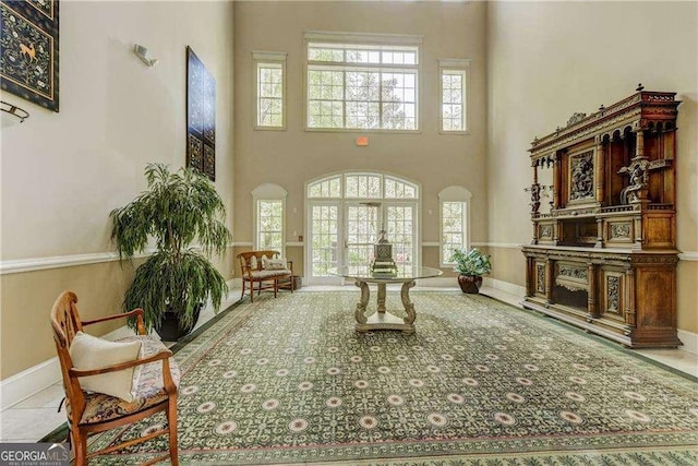 living room featuring baseboards, arched walkways, and a towering ceiling