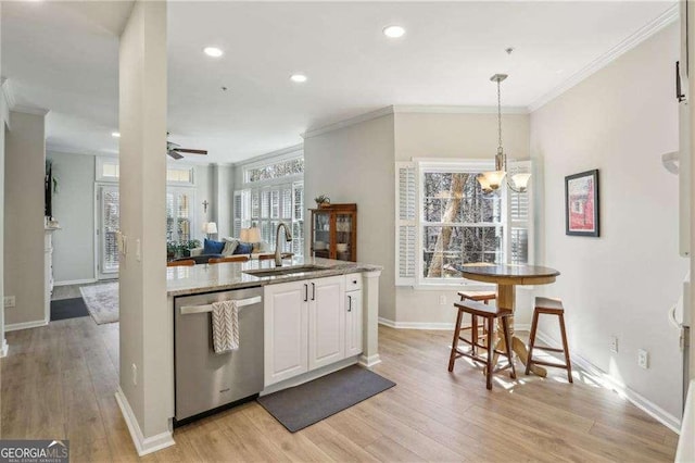 kitchen with light wood finished floors, white cabinets, dishwasher, and a sink