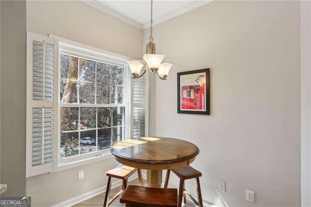 dining room with baseboards, a chandelier, and crown molding