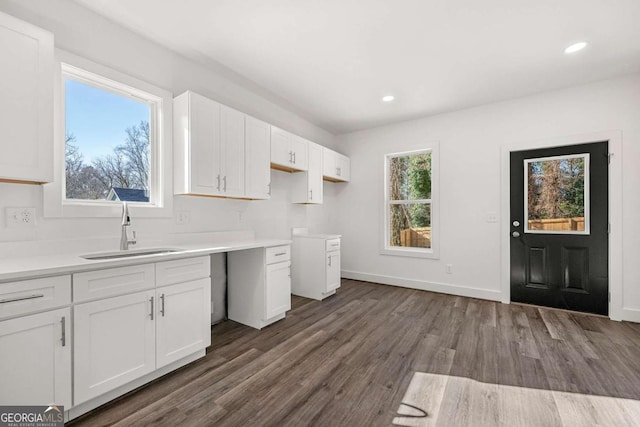 kitchen with baseboards, recessed lighting, a sink, dark wood-type flooring, and white cabinetry