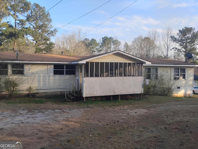 rear view of house featuring crawl space and a sunroom