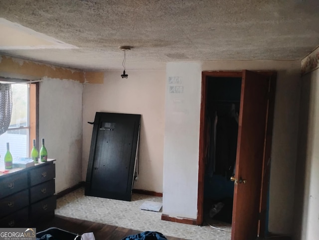 unfurnished bedroom featuring a textured ceiling and baseboards