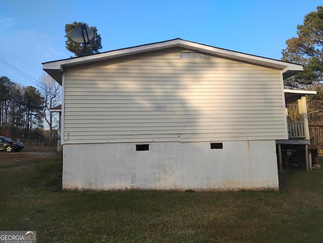 view of side of property featuring a yard and crawl space