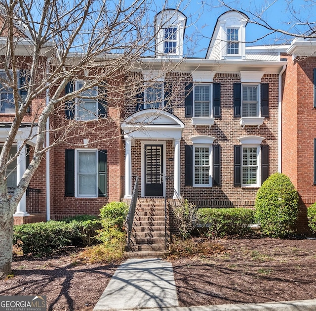 colonial-style house featuring brick siding