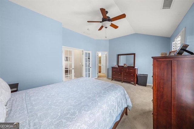 carpeted bedroom featuring lofted ceiling, a ceiling fan, and visible vents