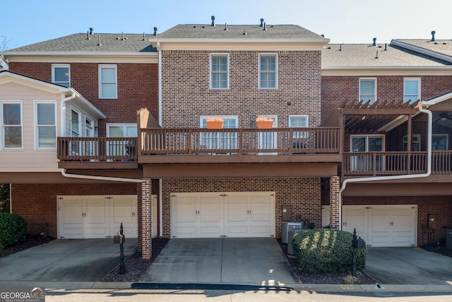 back of house with an attached garage, brick siding, and driveway