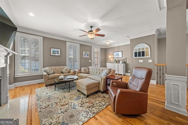 living area with light wood finished floors, a healthy amount of sunlight, baseboards, and a premium fireplace