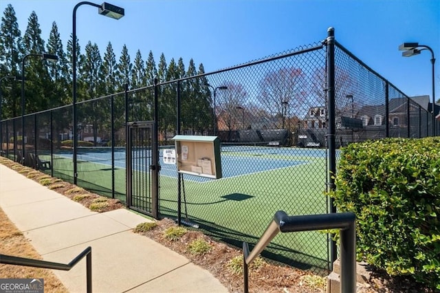 view of tennis court featuring a gate and fence