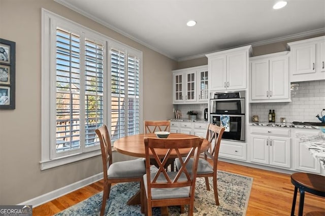 dining room with crown molding, recessed lighting, light wood-style floors, and baseboards