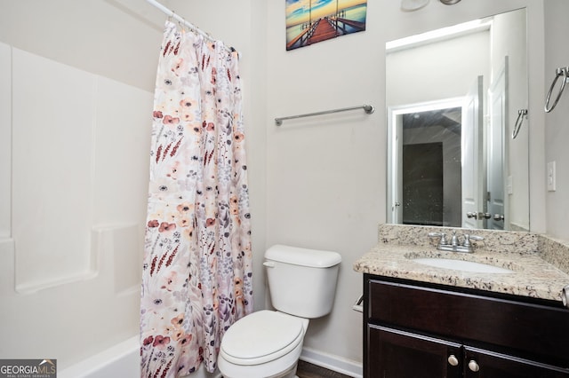 bathroom featuring toilet, vanity, baseboards, and shower / bath combo