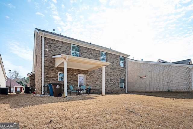 back of property featuring cooling unit, a patio, and brick siding