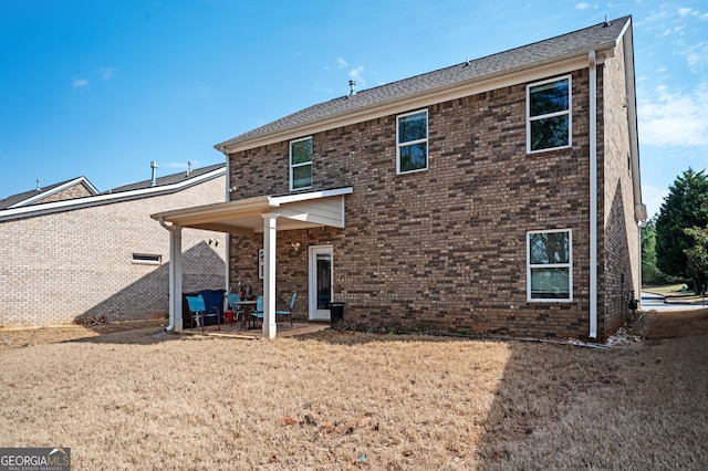 back of house featuring a patio and brick siding