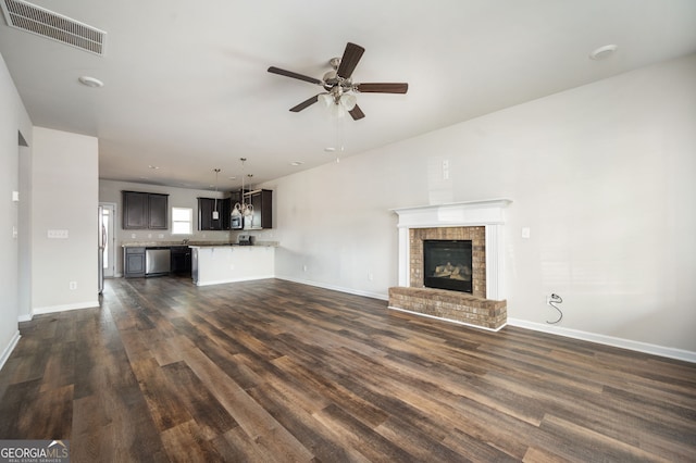 unfurnished living room with visible vents, baseboards, dark wood-type flooring, and ceiling fan