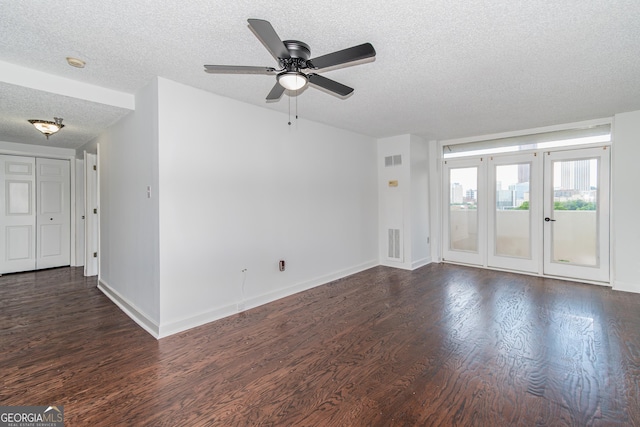 unfurnished living room with dark wood-style floors, visible vents, and ceiling fan