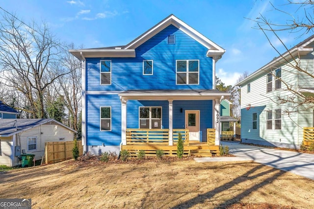 view of front of house with a porch, concrete driveway, and fence