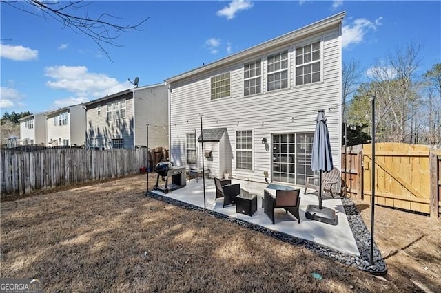 back of property featuring a patio area, a fenced backyard, and a gate