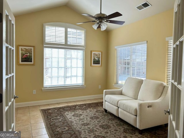 sitting room featuring tile patterned flooring, lofted ceiling, baseboards, and visible vents