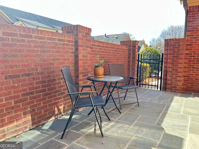 view of patio featuring a gate and fence