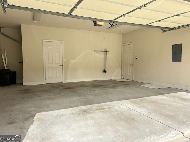 garage featuring electric panel, a garage door opener, and baseboards