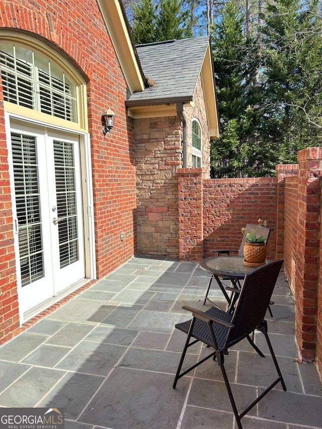 view of patio with french doors and fence