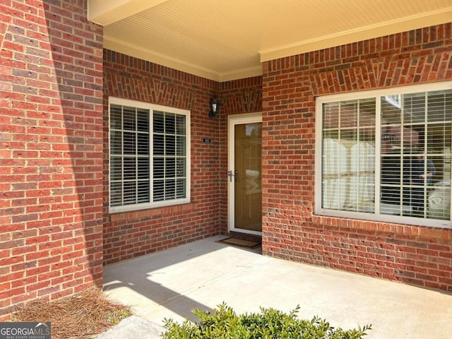 entrance to property featuring brick siding