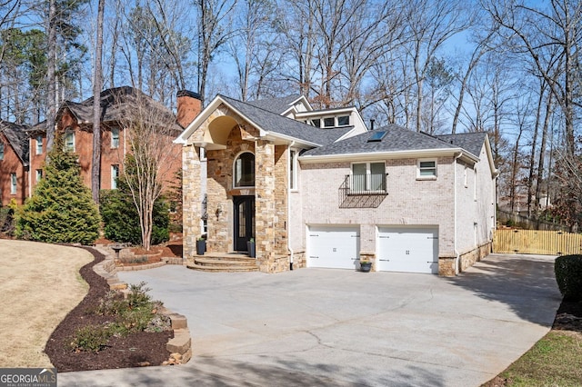 view of front of property featuring a balcony, roof with shingles, a chimney, concrete driveway, and a garage