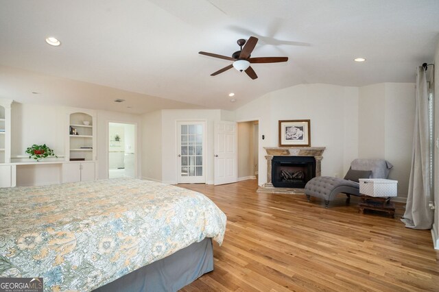 bedroom featuring recessed lighting, a fireplace, vaulted ceiling, and light wood finished floors