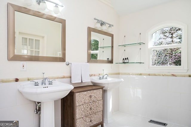 bathroom with visible vents, tile walls, and a wainscoted wall