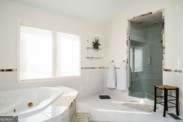 full bathroom featuring vaulted ceiling, a tub with jets, a stall shower, and tile patterned floors