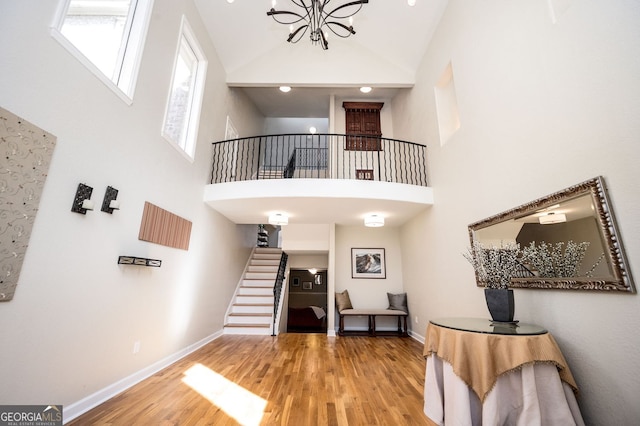 foyer entrance featuring baseboards, a high ceiling, and wood finished floors