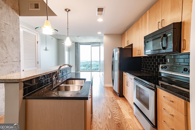 kitchen with electric range, visible vents, light brown cabinetry, a sink, and black microwave