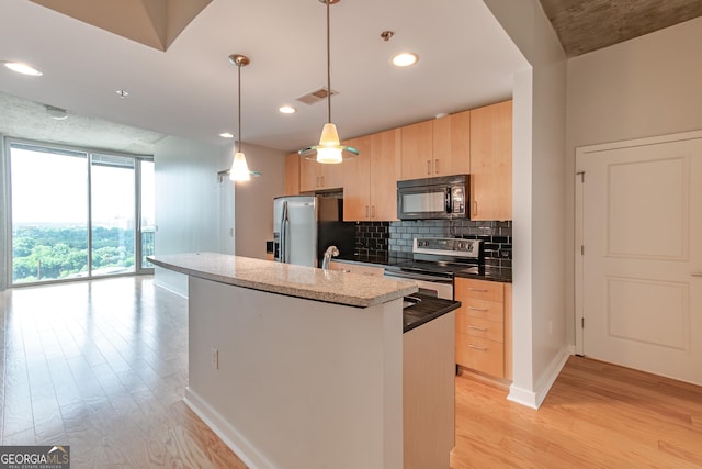 kitchen with tasteful backsplash, visible vents, light brown cabinets, light wood-type flooring, and stainless steel appliances