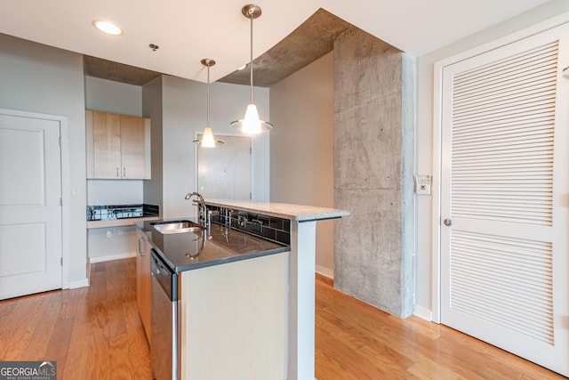 361 17th St Unit 1516, Atlanta, GA 30363 - kitchen with light wood-style floors, dishwasher, a center island with sink, pendant lighting, and dark stone countertops