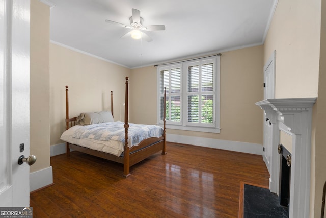 bedroom with a ceiling fan, crown molding, wood finished floors, and baseboards