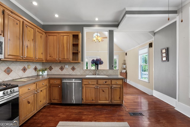 kitchen with a sink, stainless steel appliances, crown molding, dark countertops, and brown cabinets