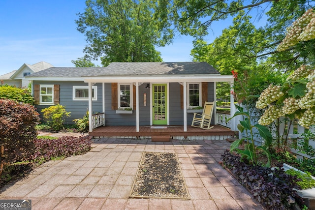 view of front of home featuring covered porch and a shingled roof