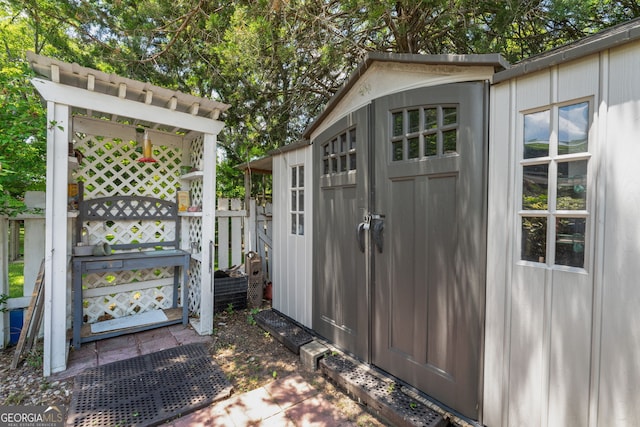 view of outbuilding featuring an outdoor structure and fence