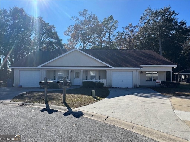 single story home with a porch, an attached garage, and concrete driveway