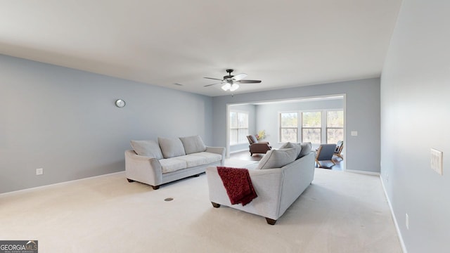 living room featuring light carpet, a ceiling fan, and baseboards