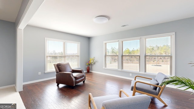 living area with visible vents, baseboards, and dark wood-type flooring