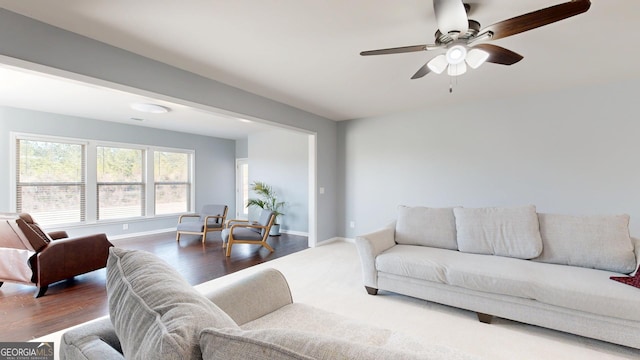 living room with baseboards, wood finished floors, and a ceiling fan