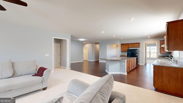 living room with baseboards, ceiling fan, recessed lighting, arched walkways, and dark wood-style floors