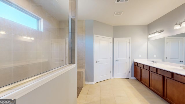 bathroom featuring tile patterned floors, visible vents, a walk in shower, and double vanity