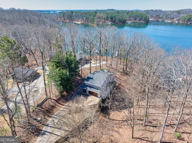 aerial view featuring a wooded view and a water view