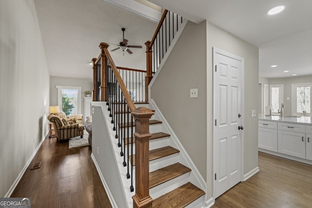 stairway with visible vents, baseboards, wood finished floors, and a ceiling fan