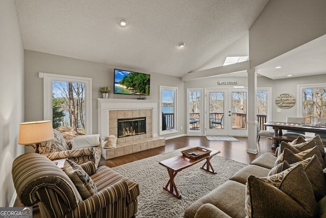 living area with ornate columns, lofted ceiling, recessed lighting, a fireplace, and dark wood-type flooring