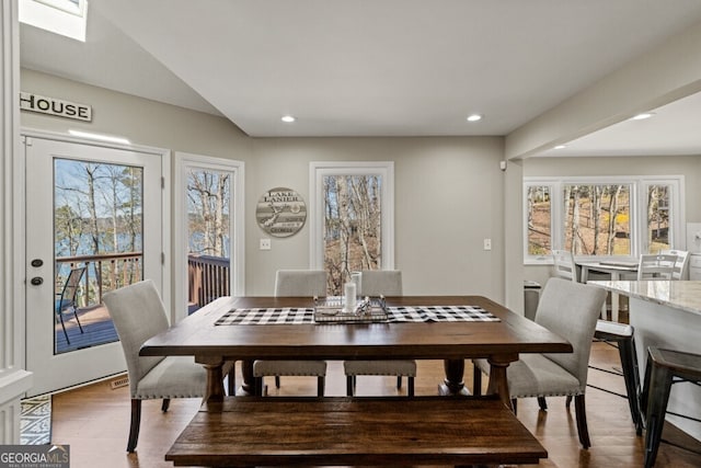 dining area with wood finished floors, a skylight, recessed lighting, and a healthy amount of sunlight