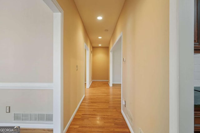 hallway with recessed lighting, visible vents, light wood-style flooring, and baseboards