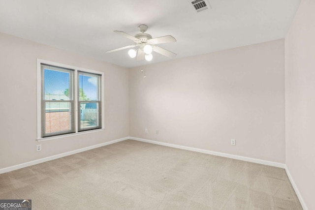 unfurnished room featuring visible vents, baseboards, light colored carpet, and ceiling fan