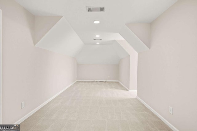 additional living space featuring baseboards, visible vents, carpet floors, lofted ceiling, and recessed lighting